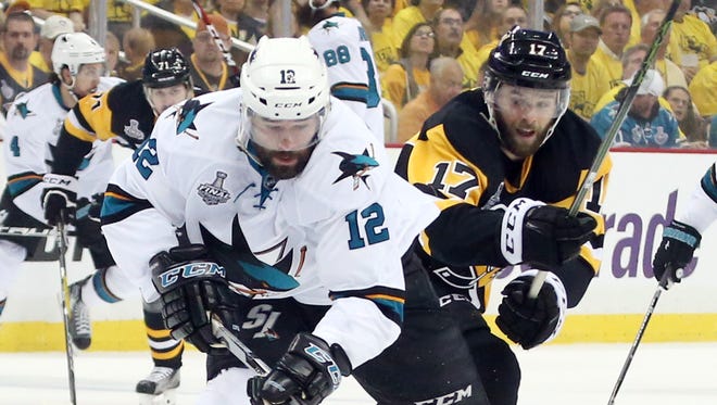 Sharks center Patrick Marleau battles for the puck with Penguins right wing Bryan Rust.