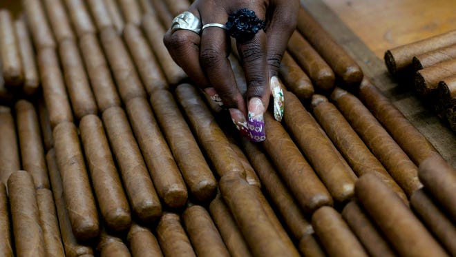 This March 1, 2013, file photo shows a worker selecting cigars at the H. Upmann cigar factory, where people can take tours as part of the annual Cigar Festival in Havana, Cuba. The Obama administration on Friday announced it is eliminating a $100 limit on the value of Cuban rum and cigars that American travelers previously faced.