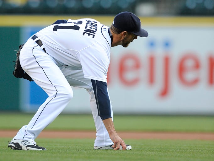 Tigers starting pitcher Shane Greene (61) picks up