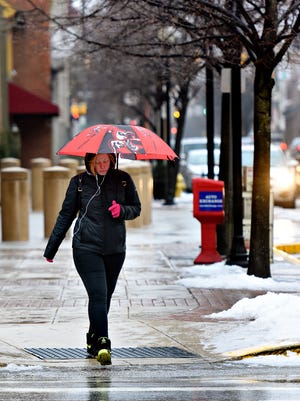 Nichole Bennett, of Hellam Township, crosses East Philadelphia Street as temperatures drop following a day of rain in York City, Wednesday, Feb. 7, 2018. Dawn J. Sagert photo