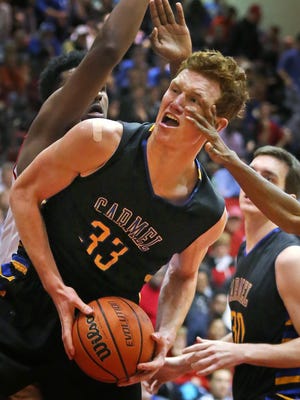 FILE -- Carmel's #33 John Michael Mulloy gets a hand in his face as he drives against North Central.