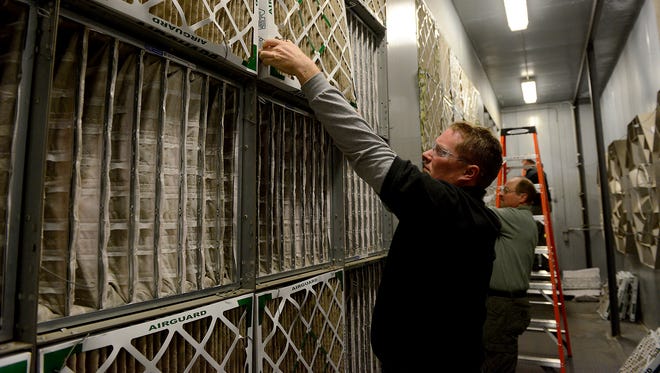 Ross Feldpausch, a maintenance mechanic, works on switching out the 100 old box air filters from the building's air supply system at the Joint Operations Building in Lansing. Maintenance workers switch the filters out twice a year - once in the year and once in fall. There are about 100 box filters and about 70 bag filters.