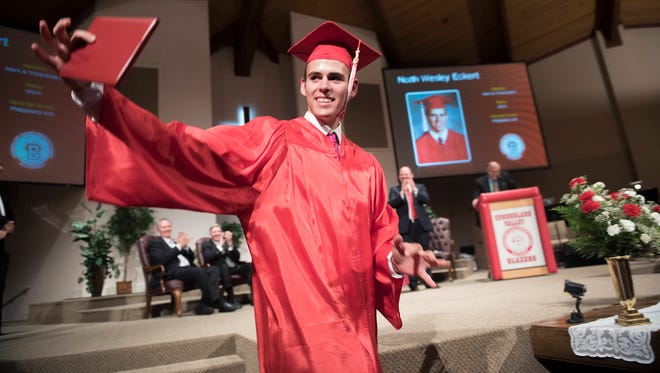 Noah Eckert holds out his diploma during the Cumberland Valley Christian School graduation on Friday, June 3, 2016.
