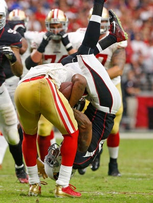 Arizona Cardinals strong safety Deone Bucannon (36) is upended by San Francisco 49ers wide receiver Michael Crabtree (15) in their NFL game, Sunday, Sept. 21, 2014, in Glendale, Ariz. The Cardinals won 23-14.