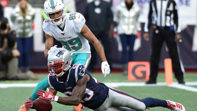 Dec 29, 2019; Foxborough, Massachusetts, USA;  New England Patriots defensive back Justin Bethel (29) downs a punt inside the 5 yard line while Miami Dolphins wide receiver Trevor Davis (89) looks on during the first half at Gillette Stadium. Mandatory Credit: Bob DeChiara-USA TODAY Sports