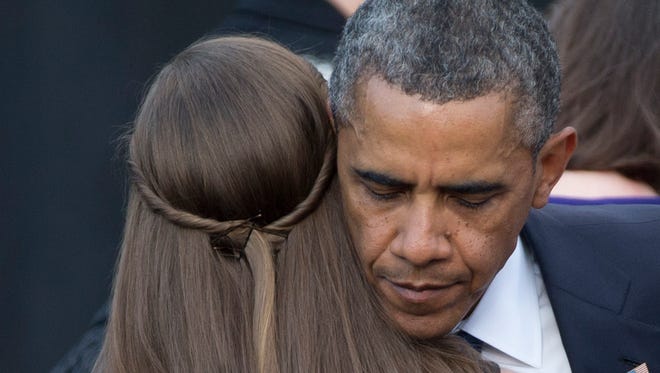 President Obama comforts a woman during a memorial service for victims of Washington Navy Yard shooting.