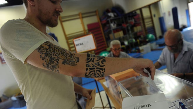 A man casts his ballot for Spain's general election at the Casa Museo in Bollullos de la Mitacion, near Sevilla, on June 26, 2016.