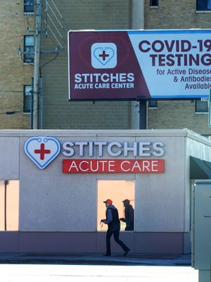 A woman walks past an urgent-care clinic offering coronavirus tests in downtown Cheyenne, Wyoming, on Nov. 16, 2020.