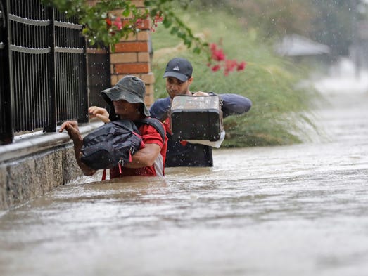 Residents wade through floodwaters from Tropical Storm