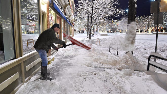 Tom Gorman shovels snow outside his business, Dean's barbershop, on Thursday, January 5, 2017. 