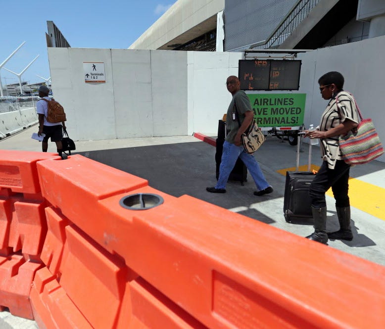 Passengers navigate barricades and temporary walls at a construction area in Terminal 1 at Los Angeles International Airport on May 11, 2017.