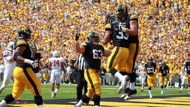 Iowa teammates surround running back Jordan Canzeri after his touchdown during their game against Illinois State at Kinnick Stadium on Saturday, Sept. 5, 2015.