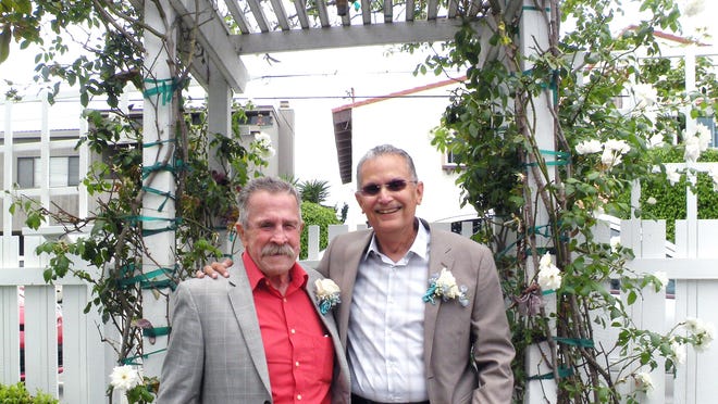 In this July 2014 photo, Fred McQuire (left) and George Martinez pose for photos at their wedding in California. Martinez was a Vietnam War veteran in the throes of the final stages of cancer when he and McQuire, his partner of 45 years, traveled from Arizona to California to fulfill one of his final wishes and get married. He died Aug. 28, 2014, and now McQuire is in the midst of a legal battle over Arizona's ban on gay marriage.