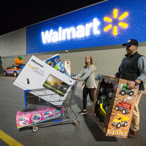 Two people with products in front of a Walmart sto