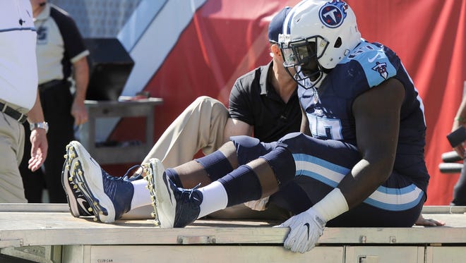 Titans offensive guard Quinton Spain (67) is carted off after being injured in the first half Sunday.