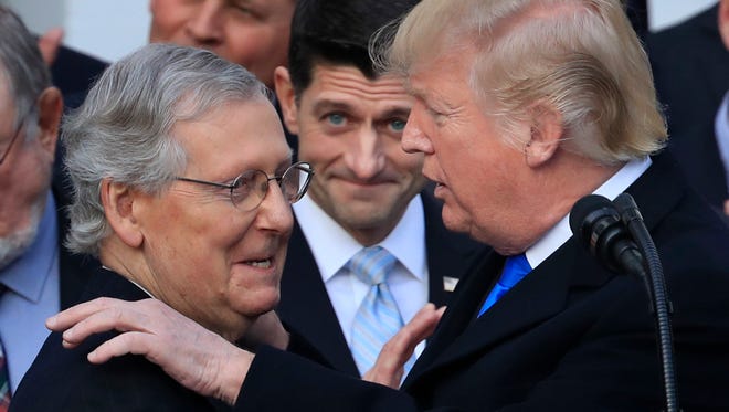 President Donald Trump congratulates Senate Majority Leader Mitch McConnell of Ky., while House Speaker Paul Ryan of Wis., watches to acknowledge the final passage of tax overhaul legislation by Congress at the White House in Washington, Wednesday, Dec. 20, 2017. (AP Photo/Manuel Balce Ceneta)