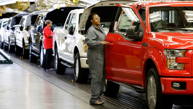 Workers inspect a new 2015 aluminum-alloy body Ford F-150 truck at the company's Kansas City Assembly Plant Friday, March 13, 2015, in Claycomo, Mo.