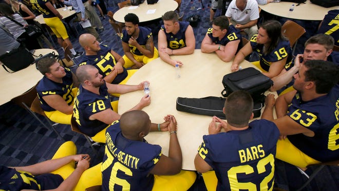 Michigan offensive lineman sit around a large table available to be interviewed during the team's football media day on Thursday, Aug. 6, 2015, in Ann Arbor.