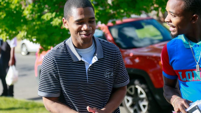 Davontae Sanford, 23, walks up with his brother DeShon Sanford, to greet his family on the lawn his mother's home in Detroit  after being released from prison on Wednesday, June 8, 2016. Devontae was released from prison after serving close to nine years for a quadruple murder officials now believe he did not commit.