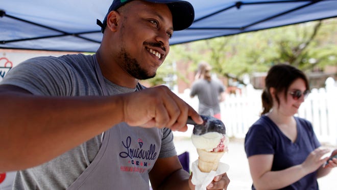 Louisville Cream Darryl Goodner, left, serves handmade ice cream to customers at the Douglas Loop Farmer's Market with the help of co-owner Lynette Ruby, right.  Aug. 6, 2016