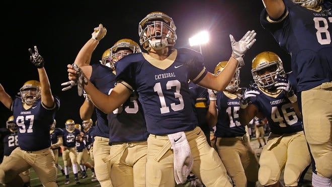 The Cathedral Fighting Irish celebrate after winning sectional finals against Lawrence Central in overtime, 20-17, at Arsenal Technical High School, Friday, November 4, 2016.