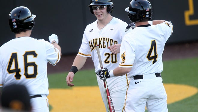 Iowa's Austin Guzzo gets high-fives as he runs in a score during the Hawkeyes' game against Loras College at Duane Banks Field on Wednesday, Feb. 22, 2017.