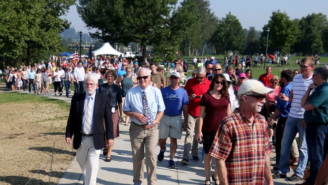 Hundreds of people, including Salem Mayor Chuck Bennett and Sen. Peter Courtney, march to the Peter Courtney Minto Island Bridge for the grand opening celebration at Riverfront Park in Salem on Wednesday, Aug. 2, 2017.