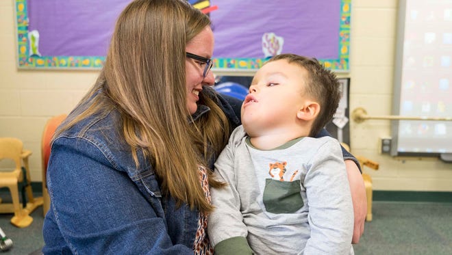Jamie Welser holds her son Ben in his classroom at the Woodlands Developmental Center Nov. 7. Welser adopted Ben after he was found abandoned on the porch of an 11th Street home in Port Huron in 2014.