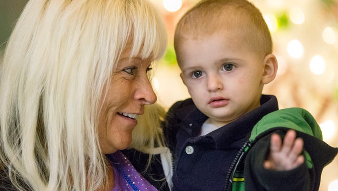 Kimberly Bennett smiles for a picture with one-year-old grandson Waylon Powers during the holiday open house at the Ronald McDonald House, Indianapolis, Tuesday, Nov. 28, 2017. Bennett has been staying at the Ronald McDonald House while caring for Powers, who has undergone chemotherapy and radiation treatment for a brain tumor. 