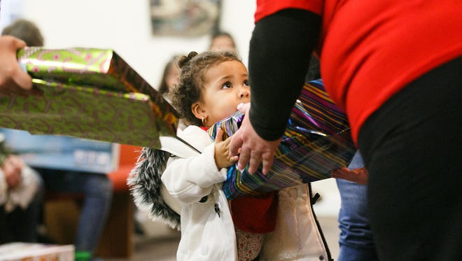 Eris Cleveland looks up as she is presented with a gift at the Tabernaculo de Salem's Christmas of Hope event on Saturday, Dec. 16, 2017. More than 200 children received gifts at the third annual event, where children of incarcerated parents or family members receive gifts on theirÊbehalf.