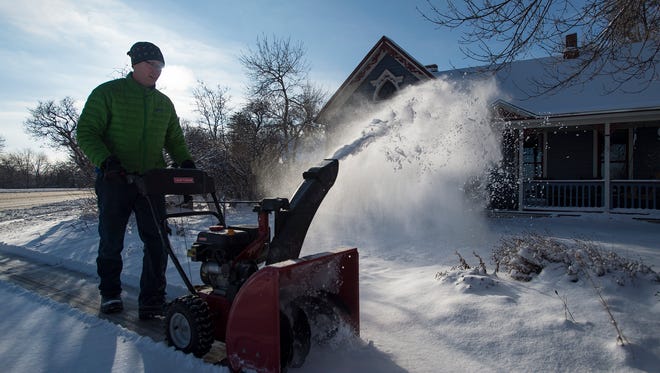 Fort Collins resident Sean Windsor runs his snowblower down his neighbor's sidewalk on Tuesday morning, Feb. 20, 2018, in Fort Collins, Colo.