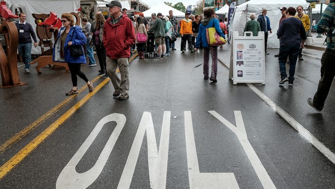 Despite some rain people turn out in large numbers for the East Lansing Art Festival Saturday, May 19, 2018.