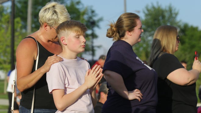 Jessica and Zachary Armstrong stand together in prayer during a vigil held at Federal Hill Commons in Noblesville Saturday, May 26, 2018, a day after a shooting at Noblesville West Middle School injured a teacher and a student.
