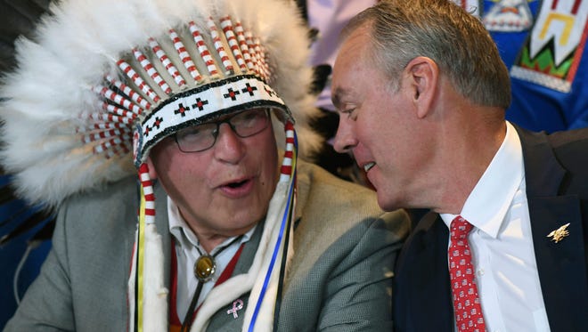 In this photo provided by the Department of the Interior Blackfeet Tribal Chairman Harry Barnes, left, speaks with U.S. Interior Sec. Ryan Zinke during a water agreement signing ceremony at the Department of Interior, Tuesday, June 12, 2018, in Washington, D.C. Barnes says the agreement gives the tribe control over 95 percent of the water on the Blackfeet's northwestern Montana reservation. (Tami Heilemann/Department of the Interior via AP)
