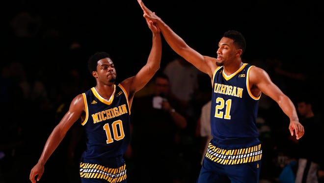 Michigan guards Derrick Walton Jr., left,  and Zak Irvin celebrate a victory over Texas in the Bahamas.