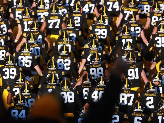 Iowa teammates swarm the field before the Hawkeyes'