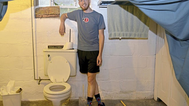 Ted Zellers stands beside a genuine Pittsburgh potty in the basement of a friend's home in the Morningside neighborhood, Wednesday, Aug. 16, 2017. He is planning a book about the bathroom phenomenon. (Pam Panchak/Pittsburgh Post-Gazette via AP)