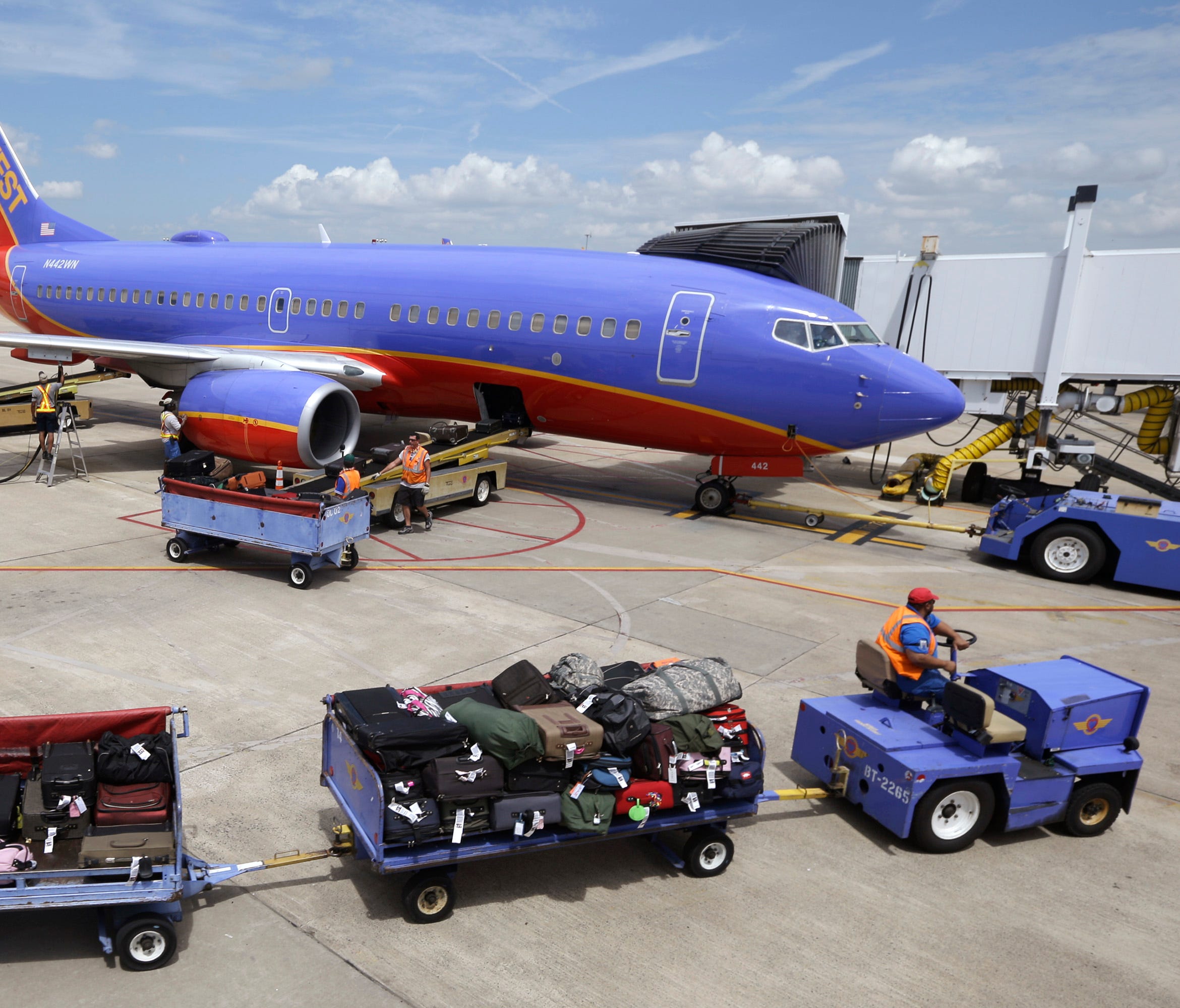 In this file photo from June 19, 2014, baggage carts are towed to a Southwest Airlines jet at Bill and Hillary Clinton National Airport in Little Rock, Ark.