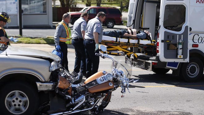 A motorcycle is pinned under an SUV.
