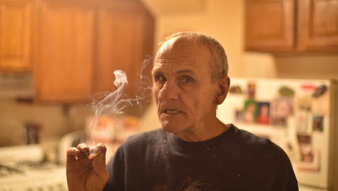 Charles Conte, 69, smokes in his public housing unit in Garfield.