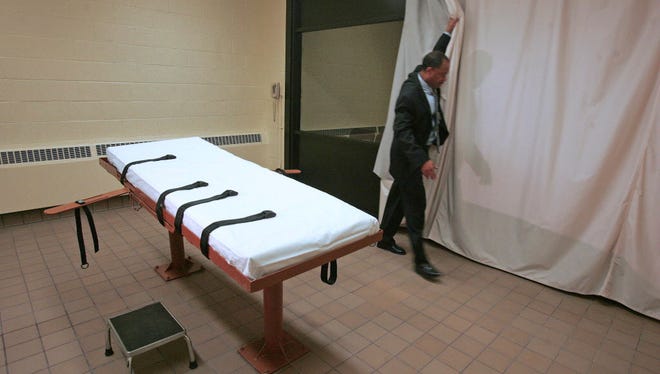 In this November 2005 file photo, Larry Greene, public information director of the Southern Ohio Correctional Facility, demonstrates how a curtain is pulled between the death chamber and witness room at the prison in Lucasville, Ohio.