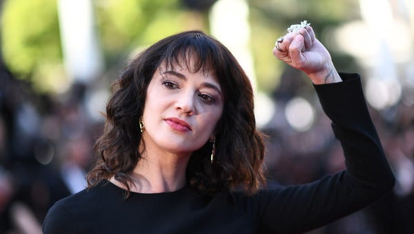 Actress Asia Argento raises her fist as she...