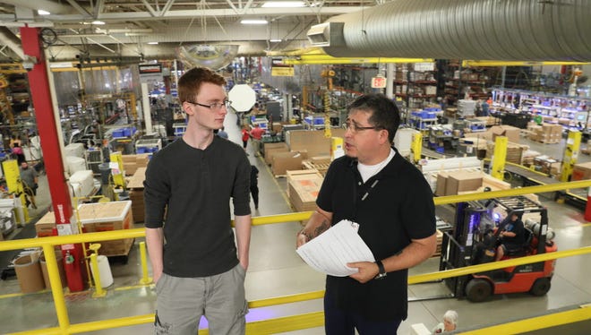 Jesus Aranda (right) a supervisor at Generac, gives Cody Kruser, 22, of Janesville a tour of the plant after his interview Wednesday at the Whitewater facility.