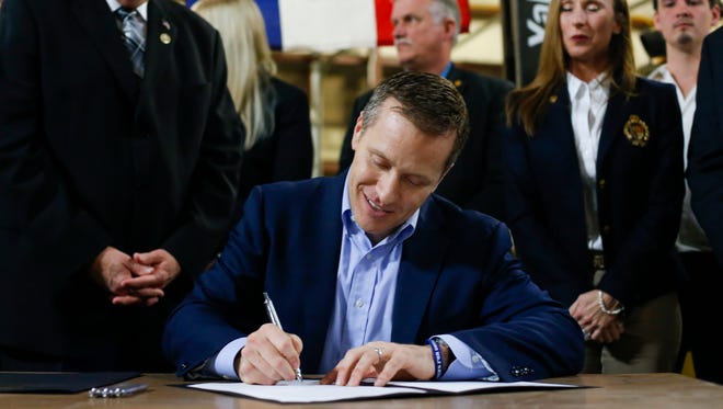 Missouri Gov. Eric Greitens signs legislation to make Missouri the 28th "right-to-work" state during a ceremonial signing at the abandoned Amelex warehouse in Springfield, Mo. on Monday, Feb. 6, 2017. The law, which goes into effect on Aug. 28, prohibits unions from charging membership dues as a condition of employment. 