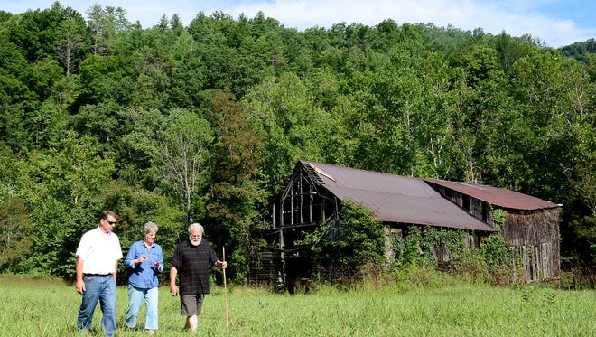 Ross Young, left, stands with Appalachian Barn Alliance lead researcher Taylor Barnhill and ABA President Sandy Stevenson at the organization's three barns at Smith Farm at Bailey Mountain Preserve. Young retired from his state role as county extension director Jan. 31 and started a new position as the county's grant program manager Feb. 1.