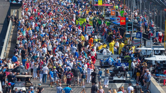 Fans crowd into the pits for a glimpse of the IndyCar machines before the start of the race at Indianapolis Motor Speedway on Sunday, May 27, 2018.