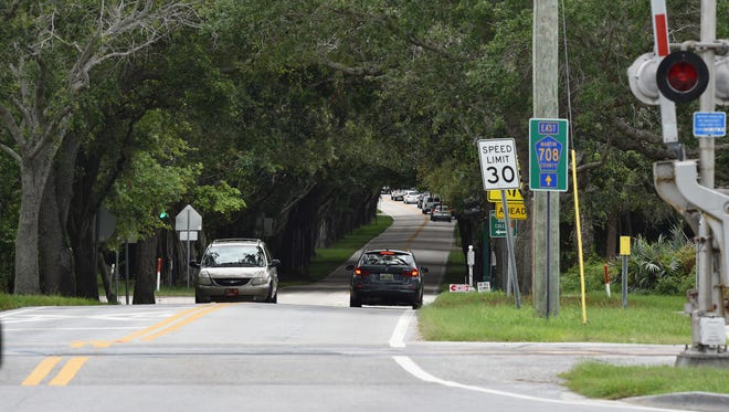 A canopy of oak trees covers Bridge Road east of Souteast Dixie Highway (A1A) on the way to the beach in Hobe Sound.