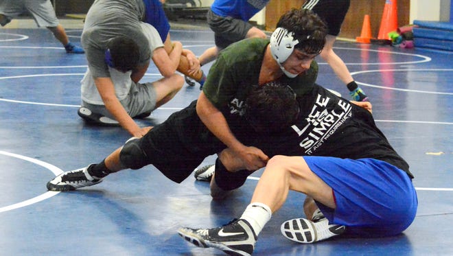 Cavemen freshman Fabian Padilla gets a firm grip wrestling sophomore Mario Carrasco toward the end of Wednesday's practice. Carlsbad will travel to Hobbs for Saturday's District 3 championships.