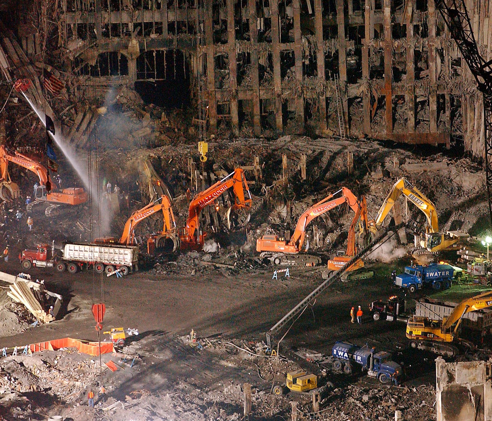 In this Nov. 7, 2001 file photo, workers and heavy machinery continue the cleanup and recovery effort in front of the remaining facade of 1 World Trade Center at ground zero in New York City.