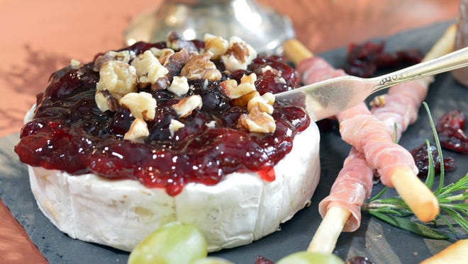 The Wisconsin Board includes a wheel of brie heated and topped with Door County cherry preserves and walnuts.